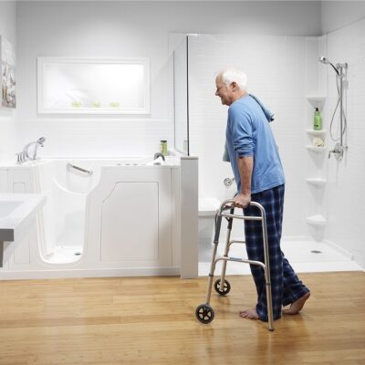 Walk-in tub and shower combo with man using a walker preparing for bath