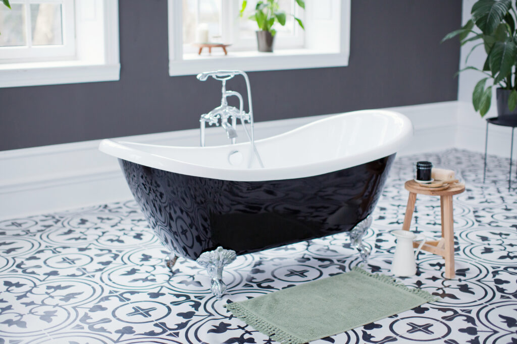 black and white bathroom with black and white clawfoot bathtub in the middle