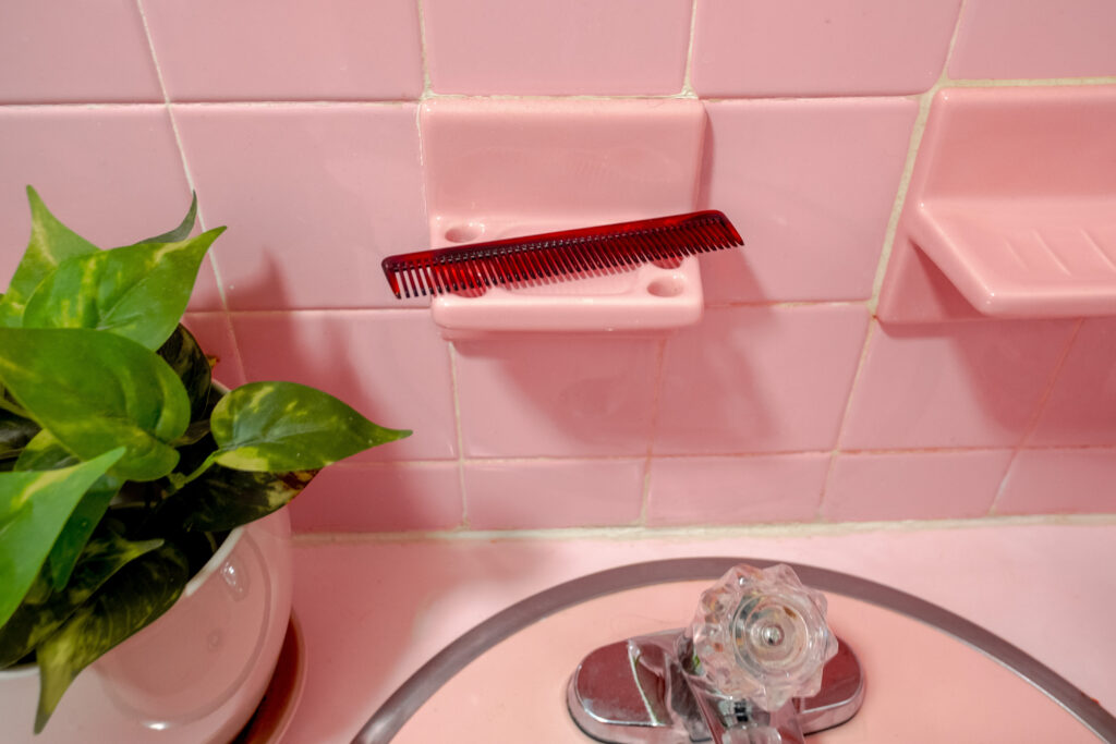 vintage pink bathroom sink with pink tile and accessories