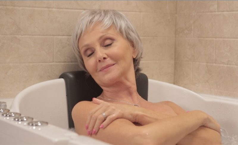 Elderly woman bathing comfortably in walk-in tub