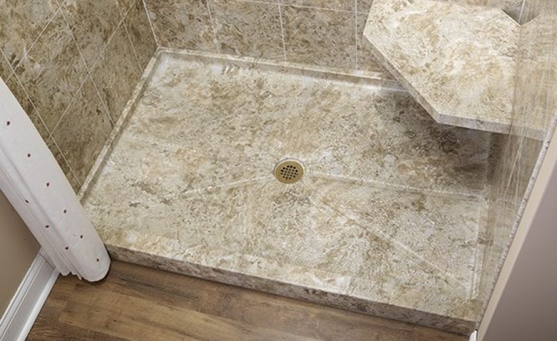 Stone shower base with accessibility bench