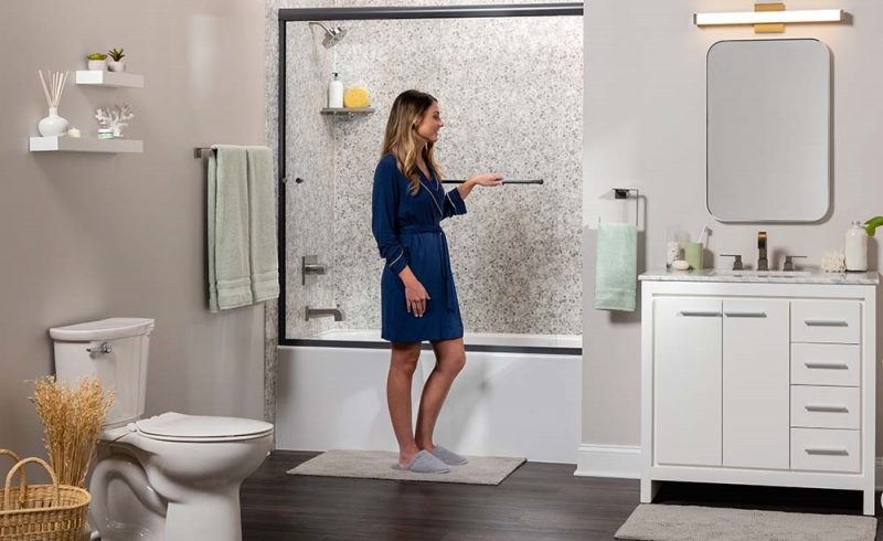 Woman preparing for shower in modern aesthetic bathroom with tiled wall